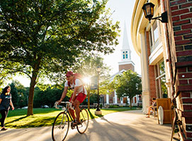 Photo of a student bicycling on campus. Links to Closely Held Business Stock