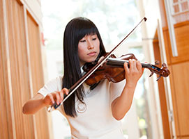 Photo of a student playing violin. Links to Gifts by Will